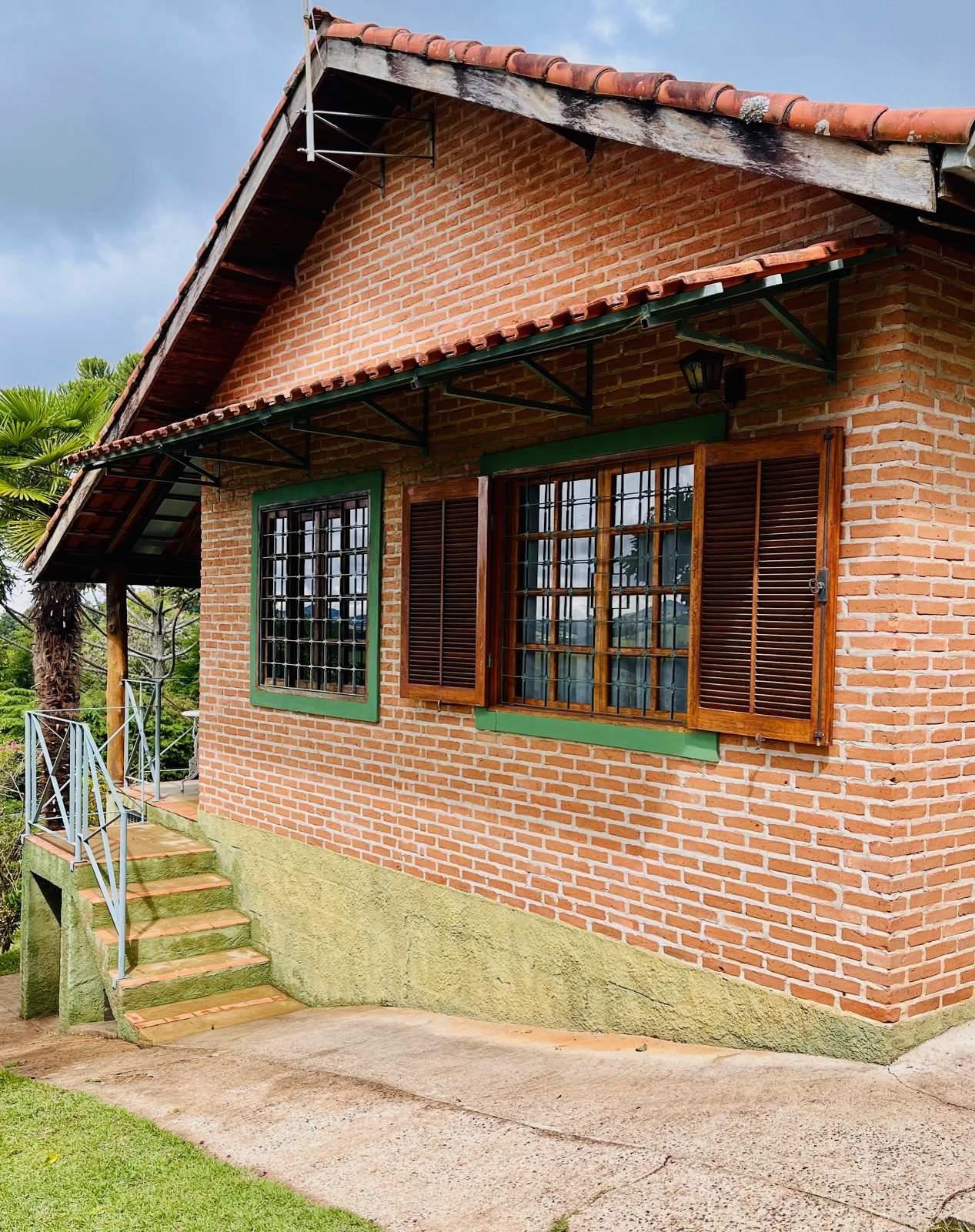 Chalé Escondidinho em tijolos aparentes cercado pelo verde