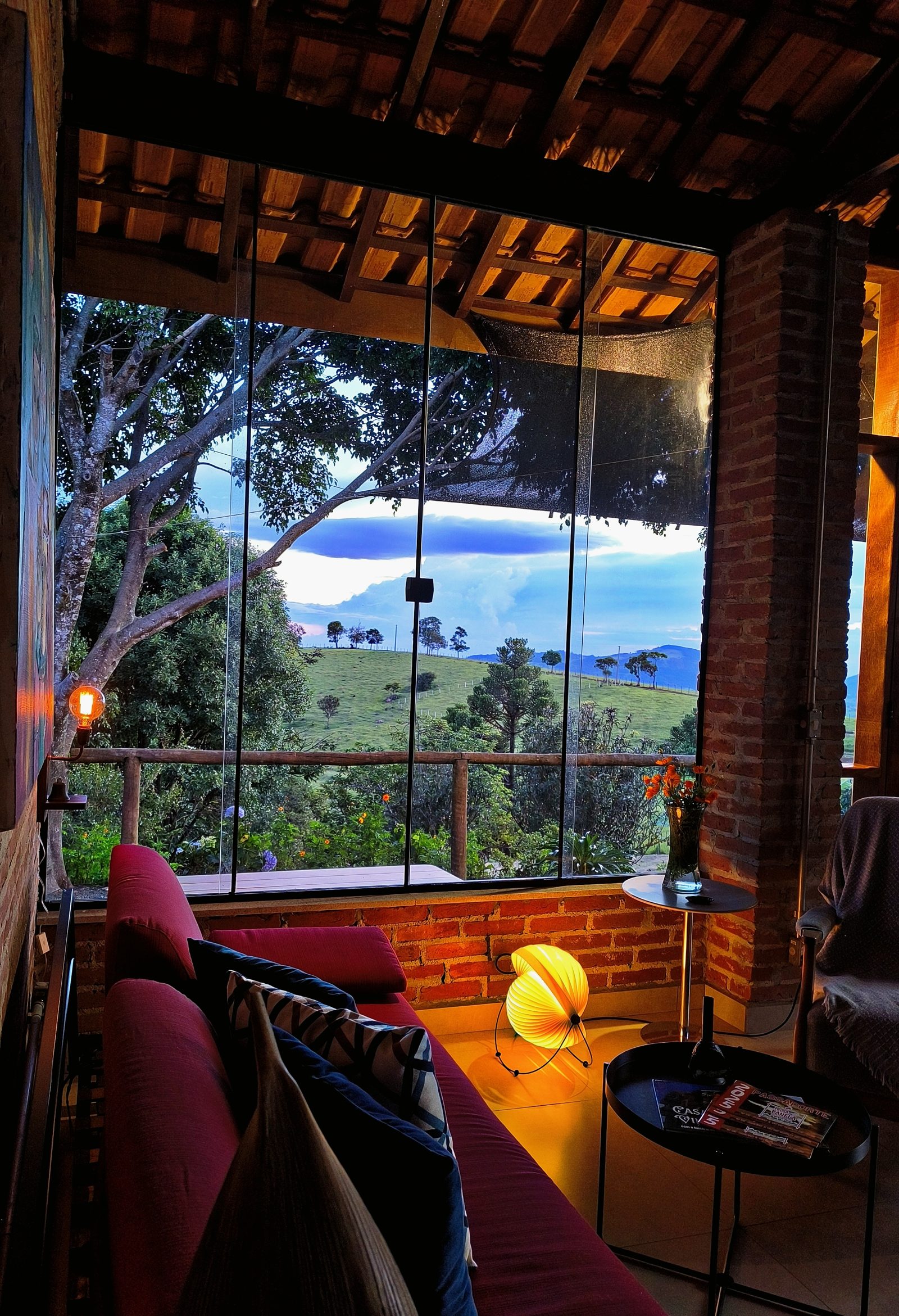 Sala envidraçada da cabana Terrinha com vista para o vale